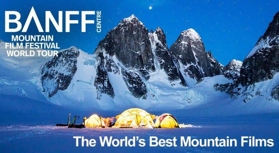 BANFF MOUNTAIN FILM FESTIVAL Poster showing lighted up tents at the snowy feet of hill-like rocks