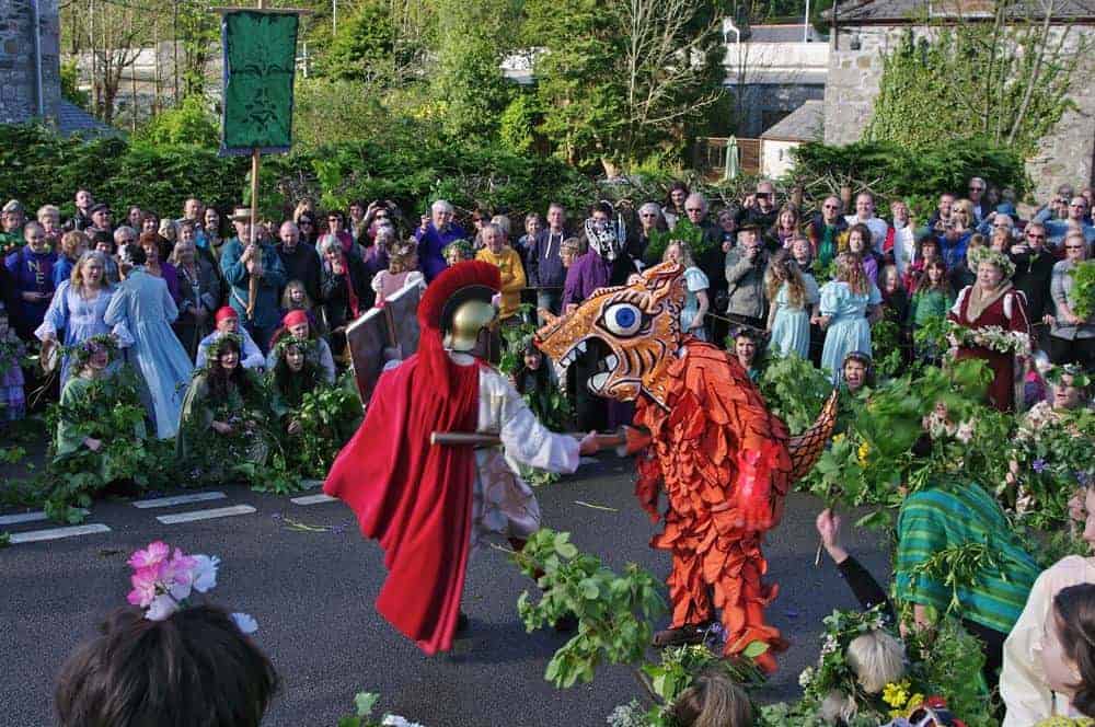 A street performance of a dragon mascot and a knight during Helston flora day