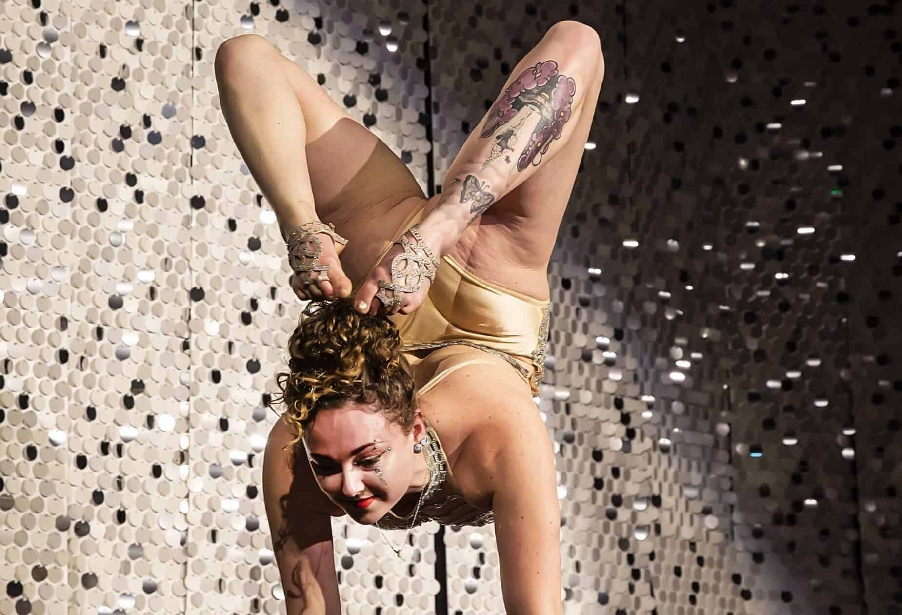 A lady standing upside down for a circus performance