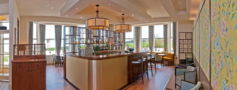 Elegant hotel bar interior with natural light and seating.