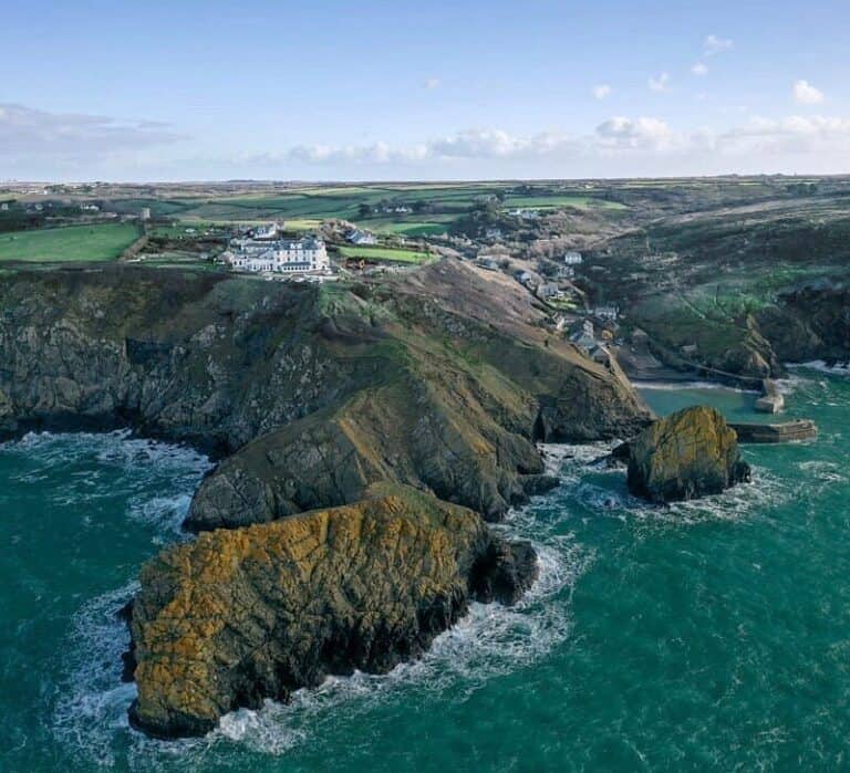 Coastal cliffs with hotel, aerial view, scenic coastline.