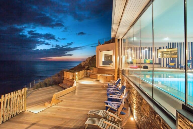 Luxury coastal home with pool at dusk
